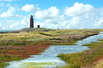 Leuchtturm auf der Hallig Langeneß - nur die Warften schauen aus den Fluten (Foto: Tourismusbüro Langeneß & Oland)