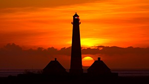 Der Leuchtturm Westerheversand beim Sonnenuntergang über der Nordsee vor der Halbinsel Eiderstedt