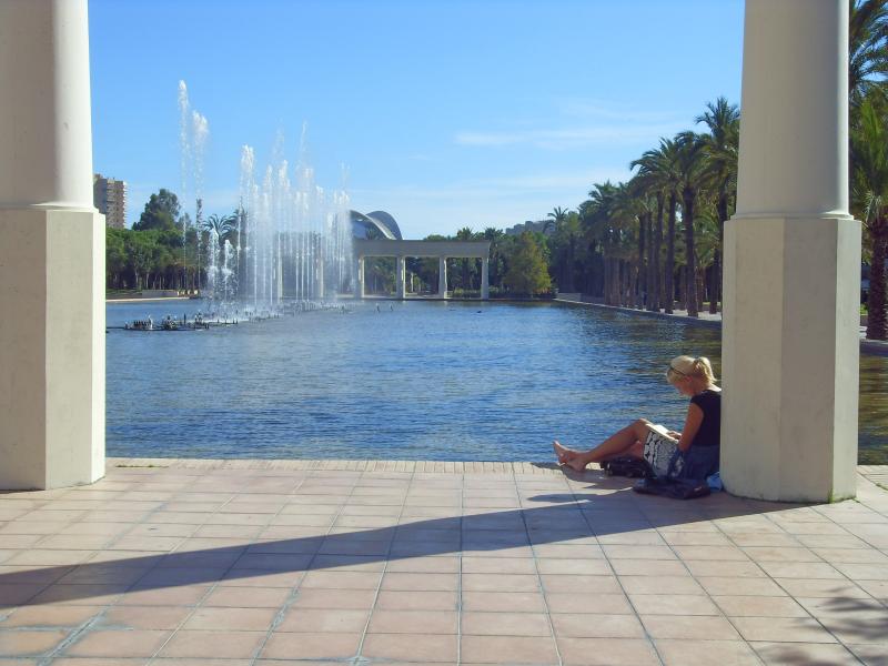 Frau liest an einer großen Wasserfläche