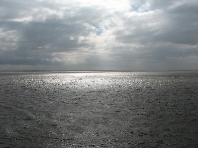 Sonnenstrahlen über der Nordsee unter dichter Wolkendecke