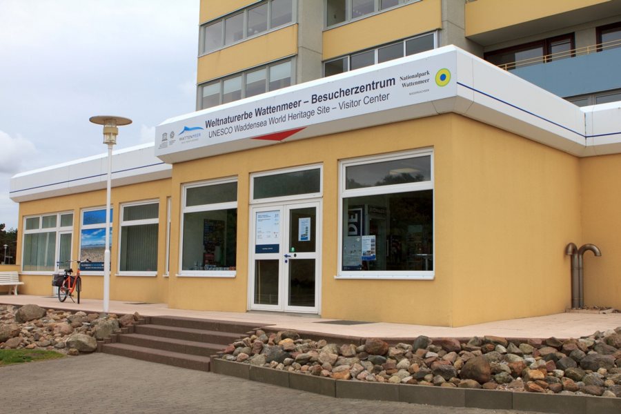 Gelbes Wattenmeer-Besucherzentrum in Cuxhaven mit Eingang und Steingarten