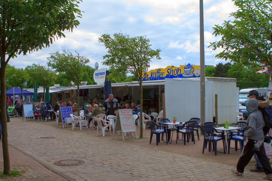 Gäste an Außentischen eines Straßencafés in Cuxhaven.